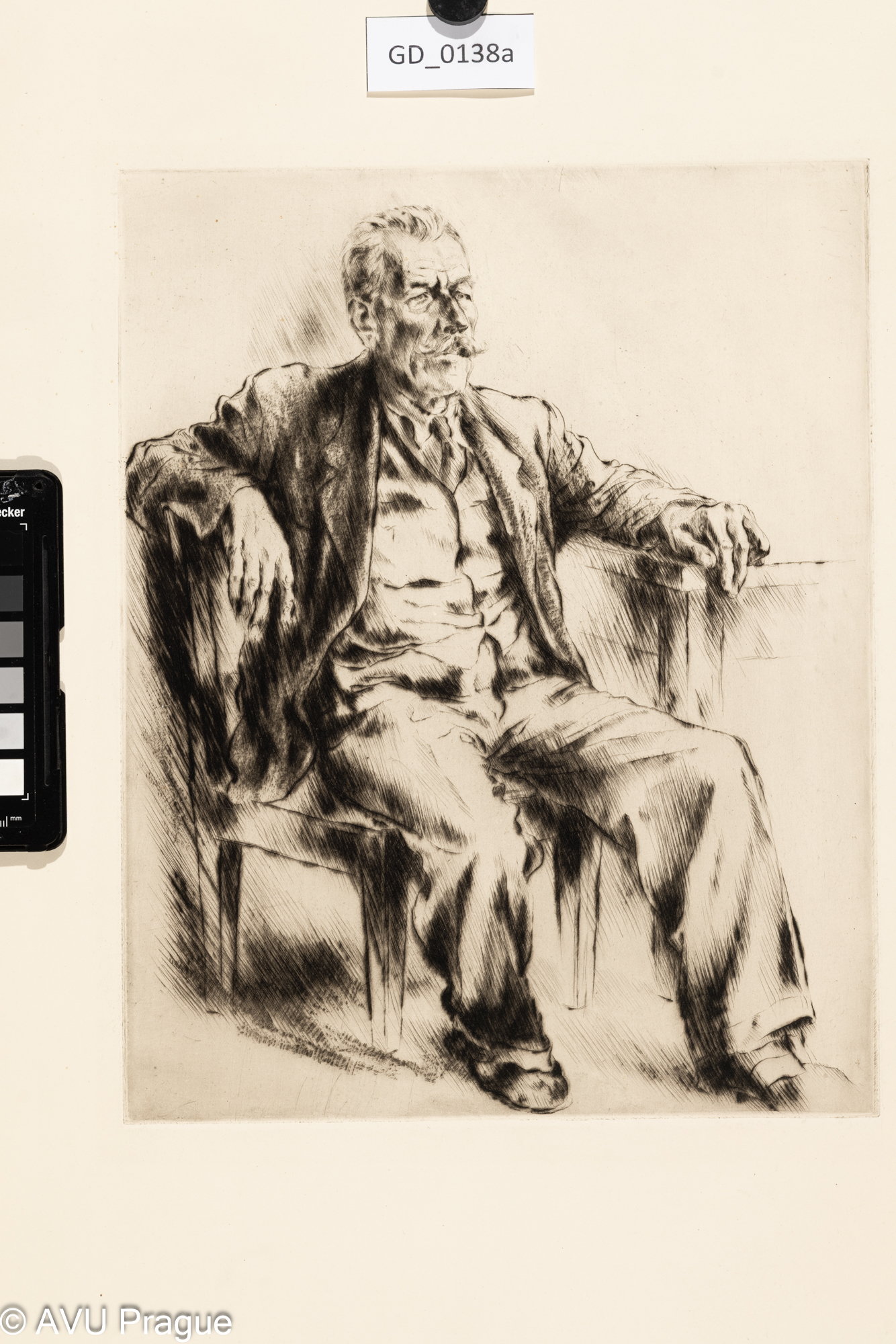 Muž s knírem  sedící u stolu